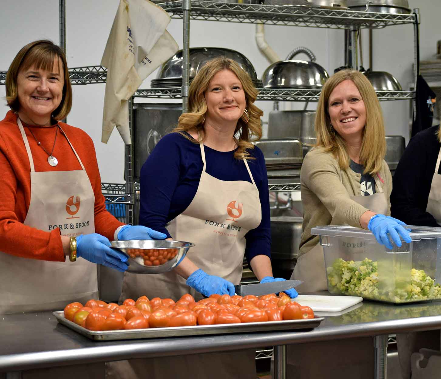 Photo of three women prepping food in the Fork & Spoon kitchen.