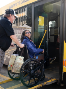 Photo of a man pushing a woman in a wheelchair on the Streamline bus. 